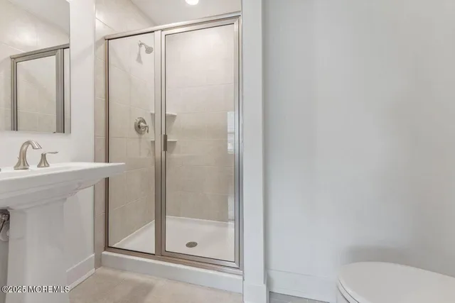 a bathroom with a shower a toilet and sink