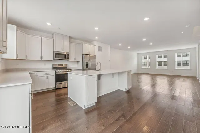 a kitchen with white cabinets stainless steel appliances and sink