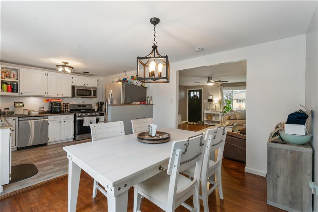 139 William Circle McKees Rocks, PA 15136 - Photo 6 of 24 a kitchen with stainless steel appliances kitchen island granite countertop a stove a refrigerator a kitchen island a dining table and chairs with wooden floor