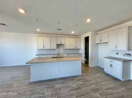 a large kitchen with kitchen island a sink stainless steel appliances and cabinets