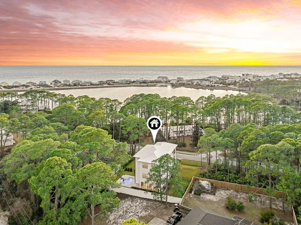 an aerial view of a city with lots of residential buildings ocean and mountain view in back