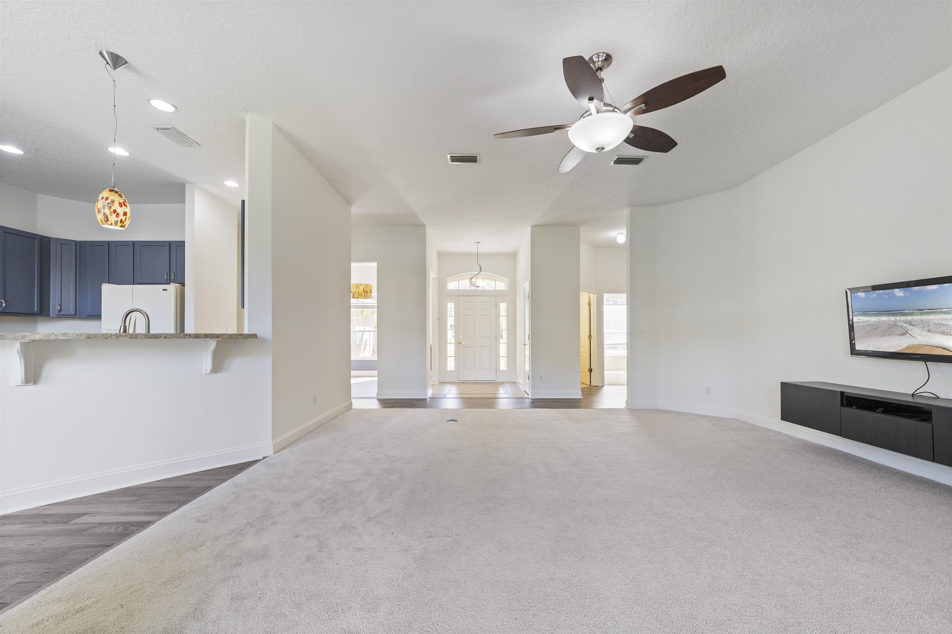 145 Whisper Ridge Drive St. Augustine, FL 32092 - Photo 12 of 43 a view of an empty room with kitchen and ceiling fan
