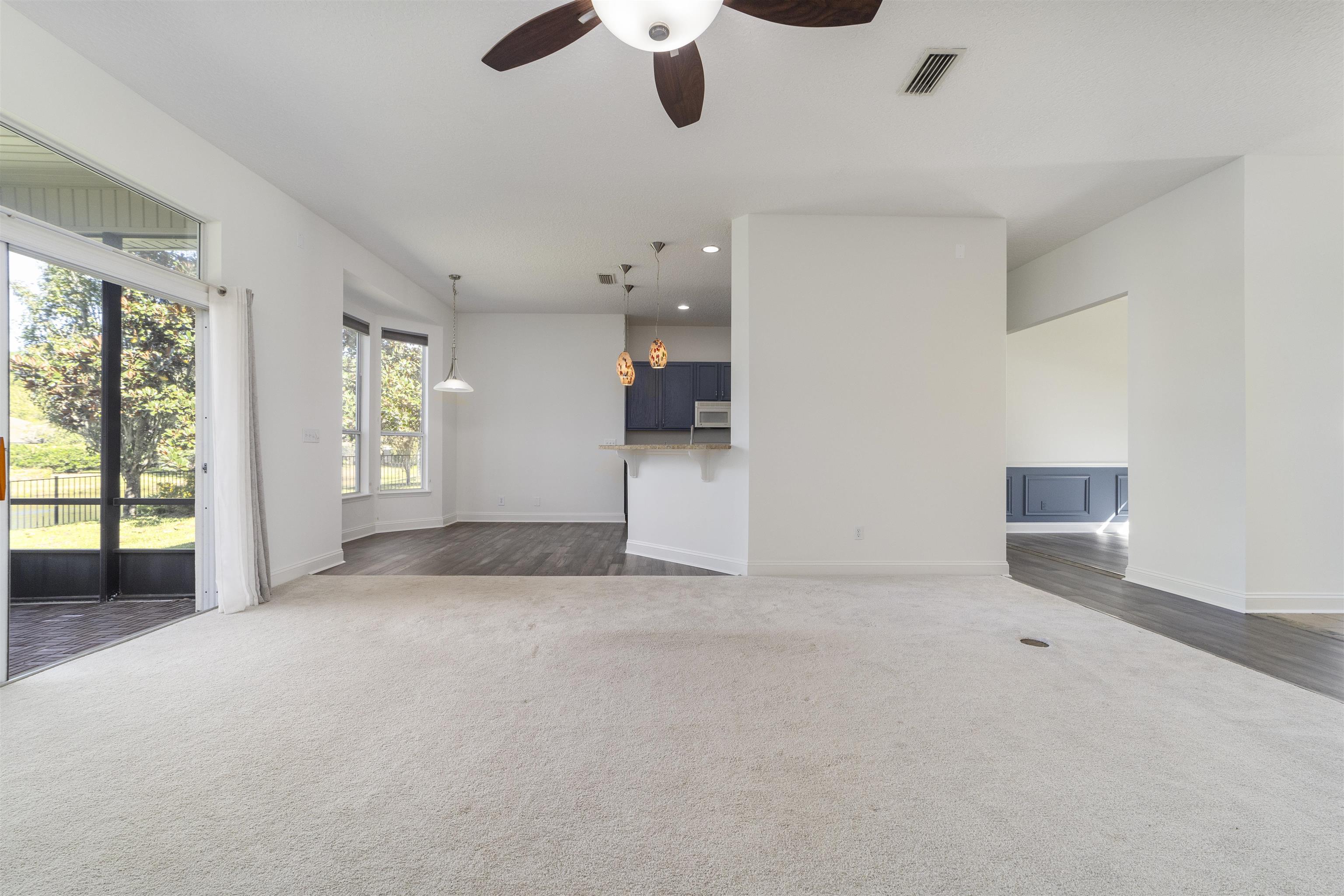 145 Whisper Ridge Drive St. Augustine, FL 32092 - Photo 20 of 43 an empty room with chandelier fan and windows