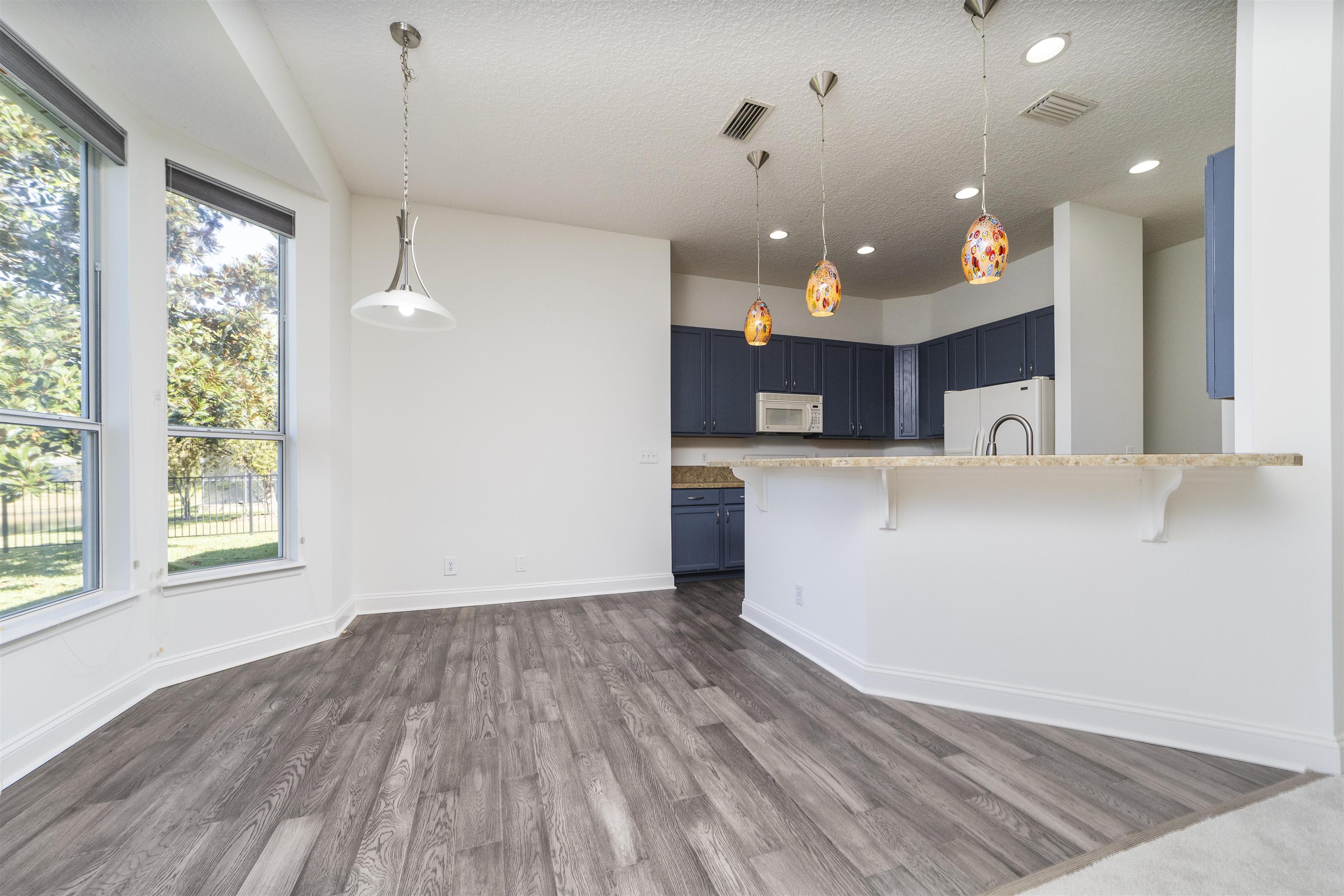 145 Whisper Ridge Drive St. Augustine, FL 32092 - Photo 21 of 43 a view of a kitchen with kitchen island a sink wooden floor and a living room view