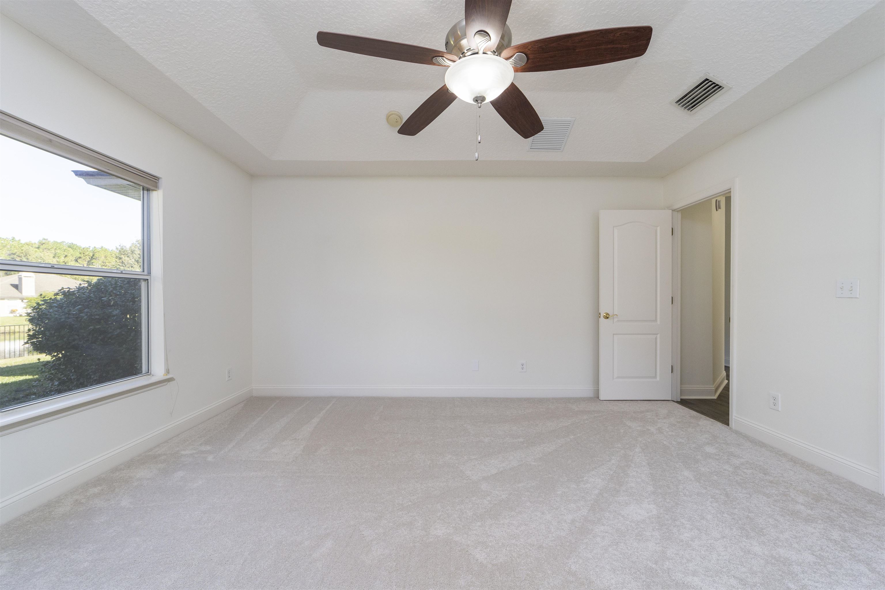 145 Whisper Ridge Drive St. Augustine, FL 32092 - Photo 27 of 43 an empty room with a window and a fan