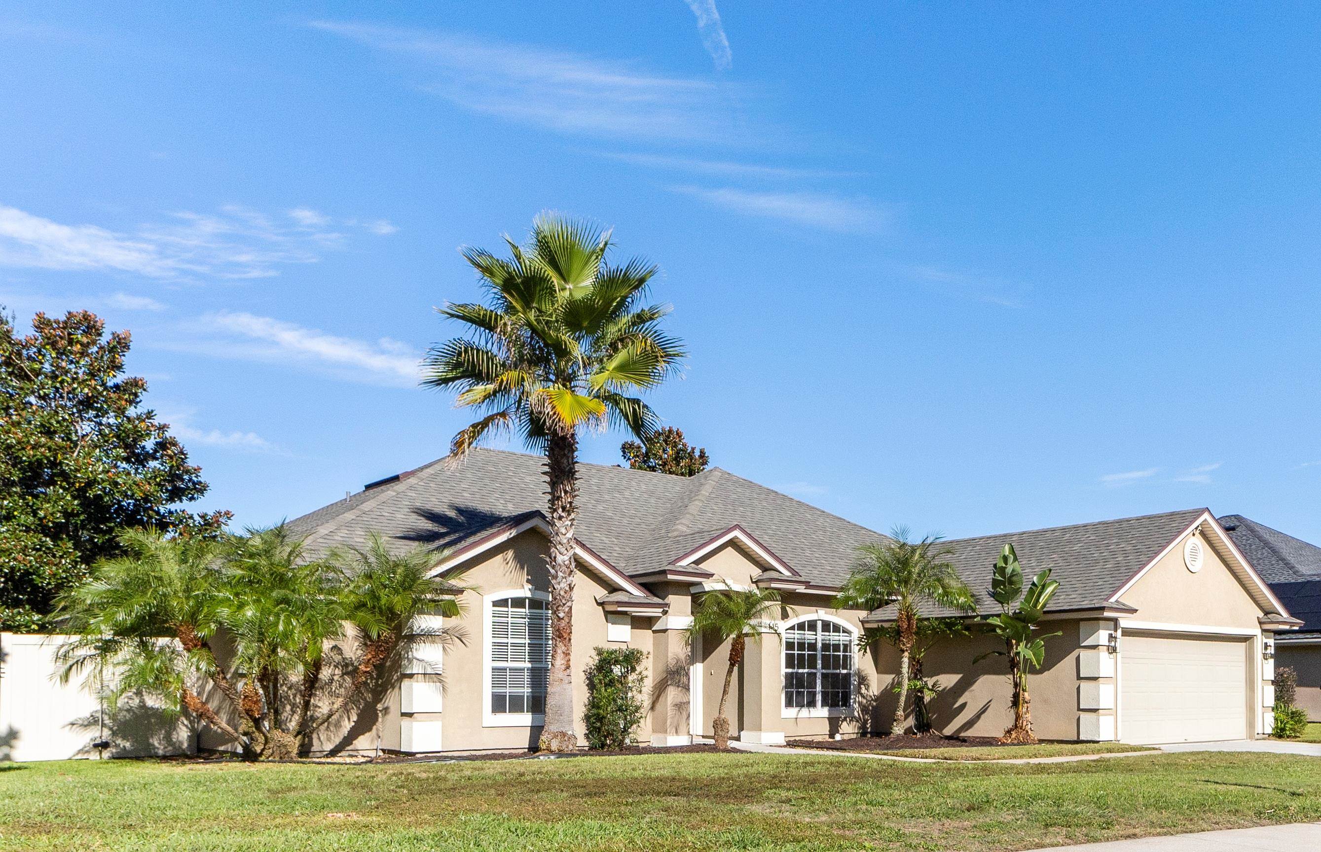 145 Whisper Ridge Drive St. Augustine, FL 32092 - Photo 10 of 43 a view of a white house with a big yard and potted plants