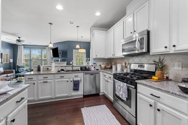 a kitchen with stainless steel appliances granite countertop a sink stove and cabinets