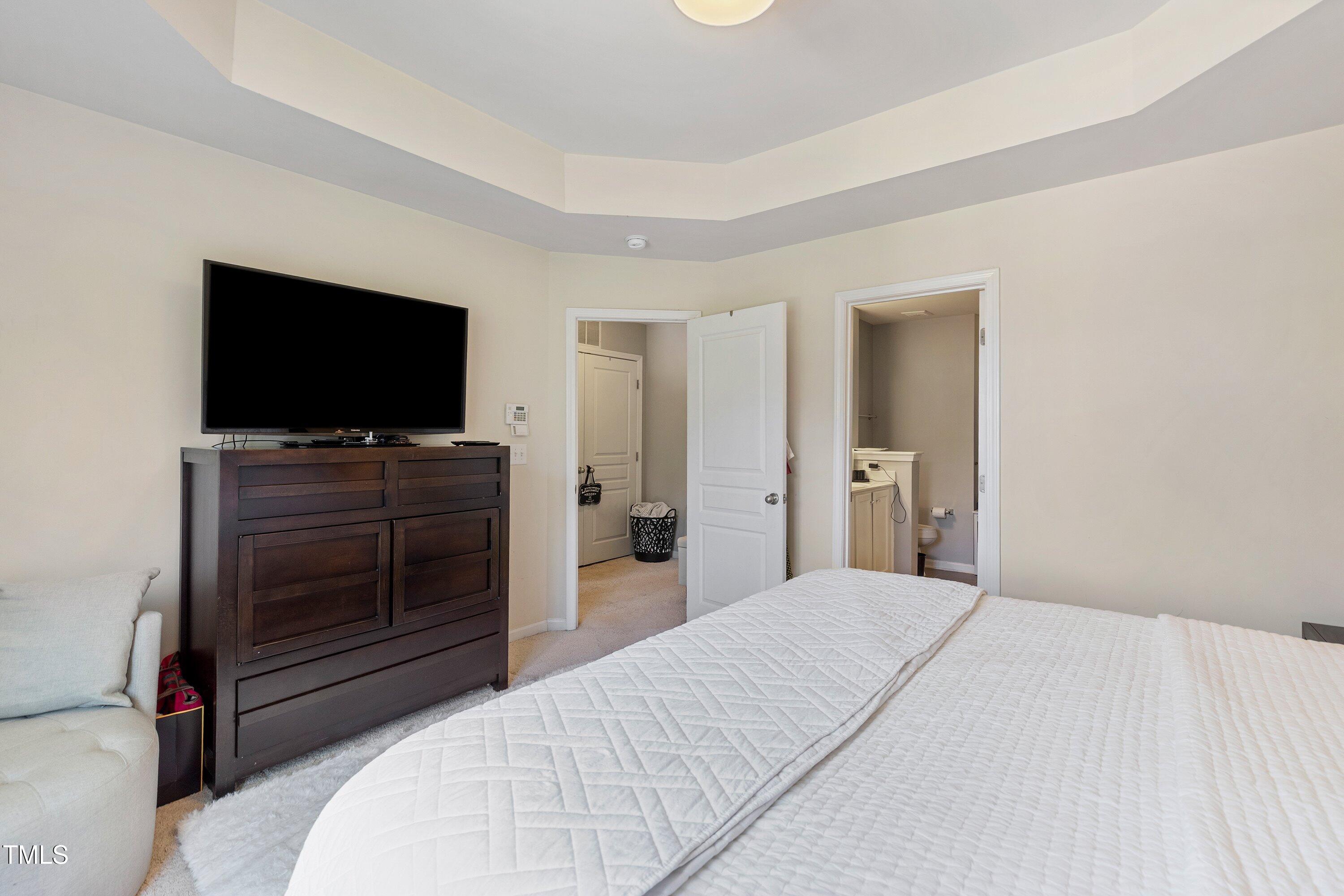 9352 Wooden Road Raleigh, NC 27617 - Photo 27 of 43 a bedroom with a bed and a flat screen tv