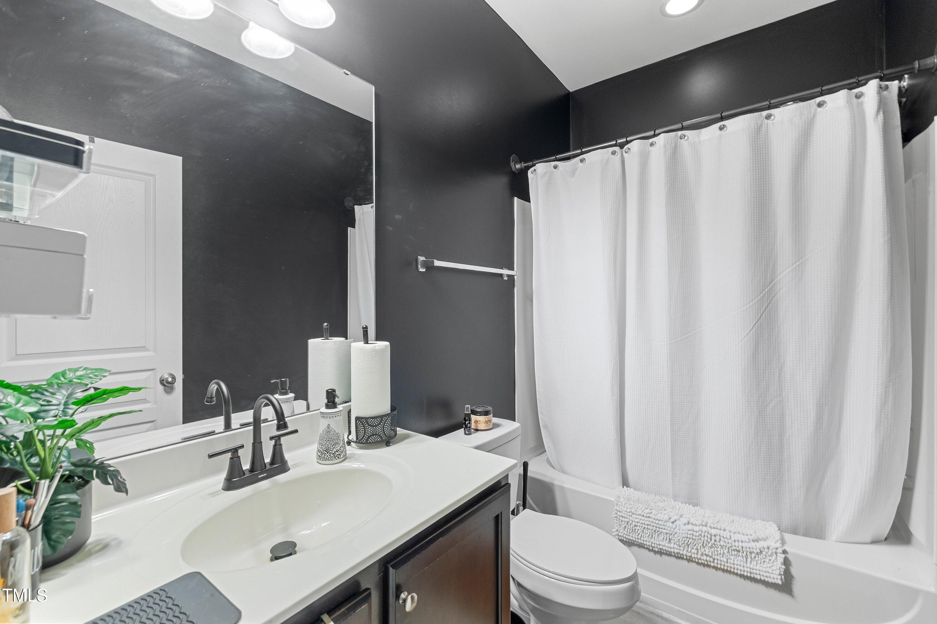 9352 Wooden Road Raleigh, NC 27617 - Photo 33 of 43 a bathroom with a sink a toilet and shower