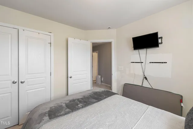 a bedroom with a bed and a flat screen tv