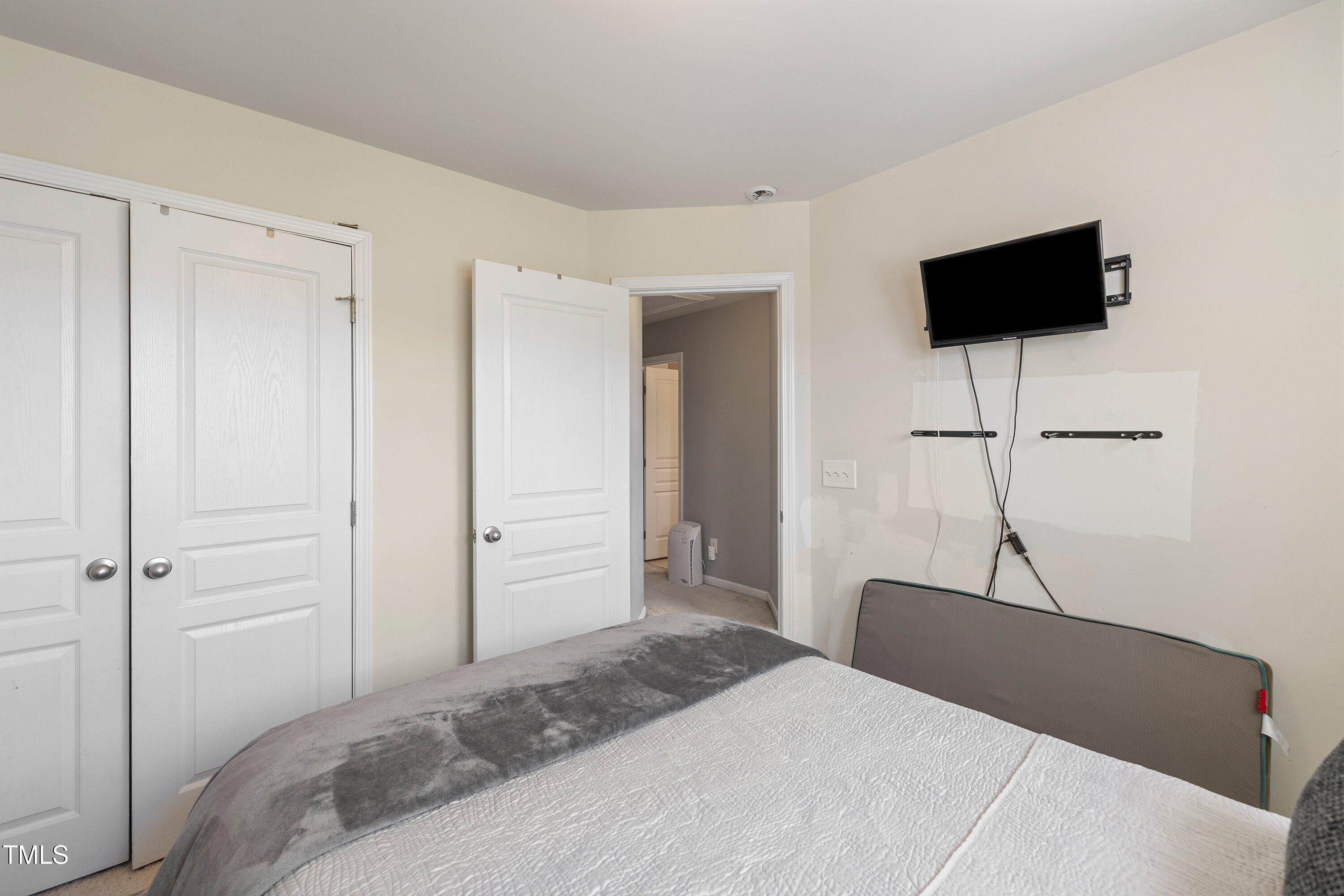 9352 Wooden Road Raleigh, NC 27617 - Photo 35 of 43 a bedroom with a bed and a flat screen tv