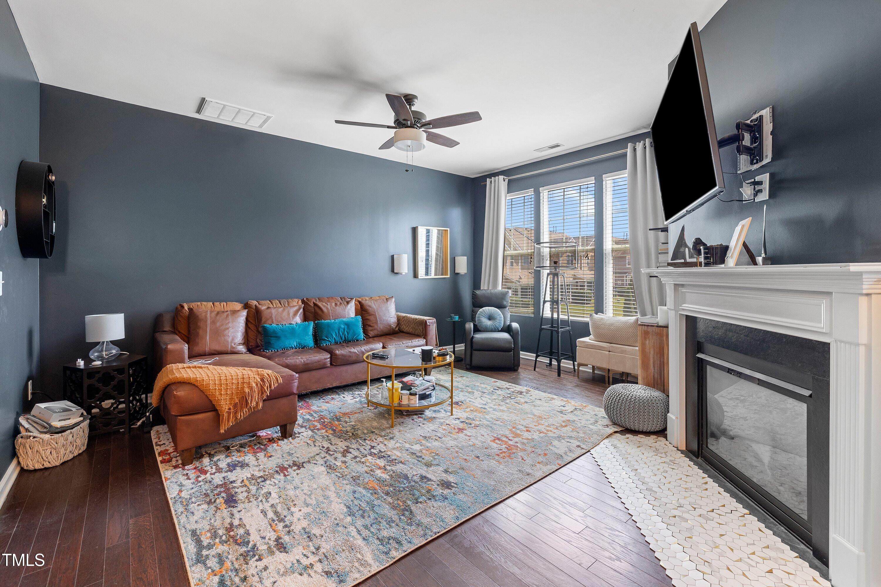 9352 Wooden Road Raleigh, NC 27617 - Photo 8 of 43 a living room with furniture a fireplace and a flat screen tv