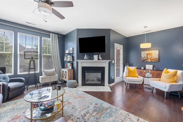 a living room with furniture a flat screen tv and a fireplace