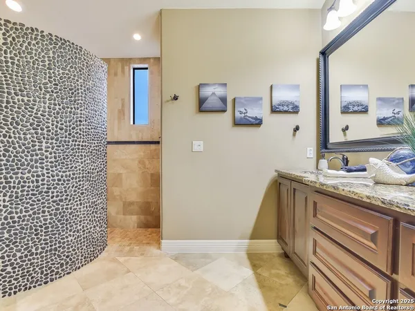 a bathroom with a granite countertop sink a mirror and a shower