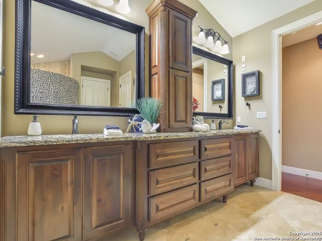 a bathroom with double vanity and a mirror
