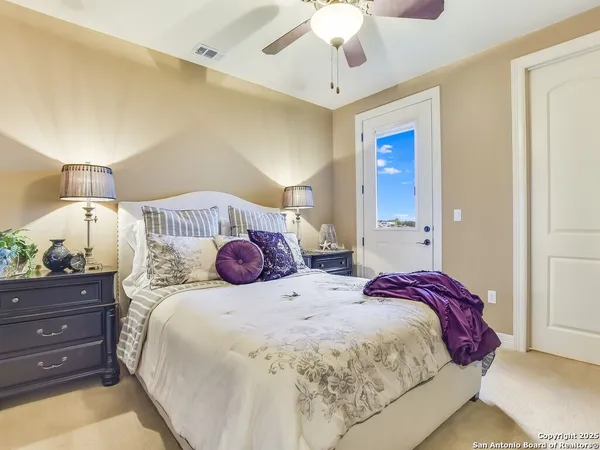 a bedroom with a bed and a lamp on dresser