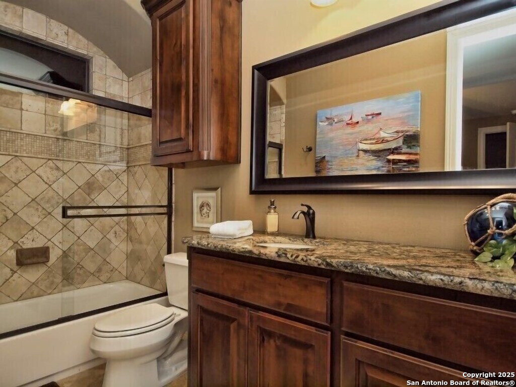 21913 Mockingbird Street Lago Vista, TX 78645 - Photo 18 of 39 a bathroom with a granite countertop sink a toilet and a mirror