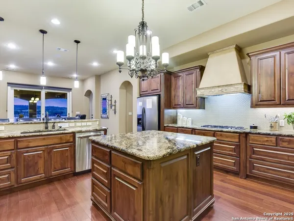 a kitchen with center island wooden cabinets and refrigerator