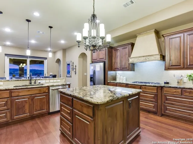a kitchen with center island wooden cabinets and refrigerator