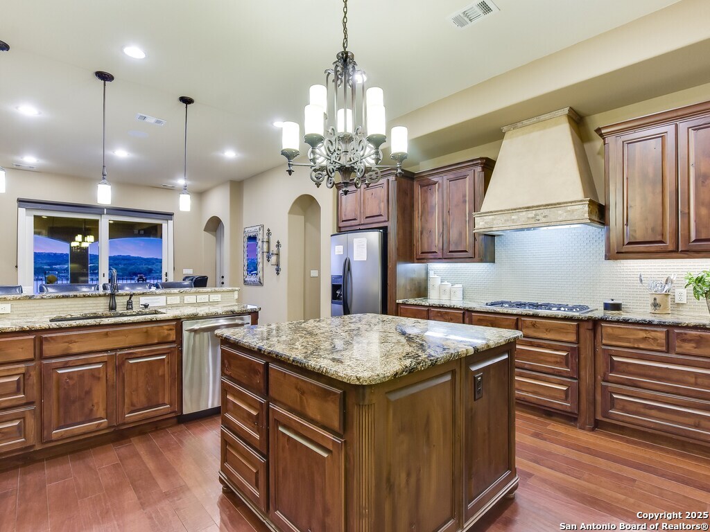 21913 Mockingbird Street Lago Vista, TX 78645 - Photo 8 of 39 a kitchen with center island wooden cabinets and refrigerator