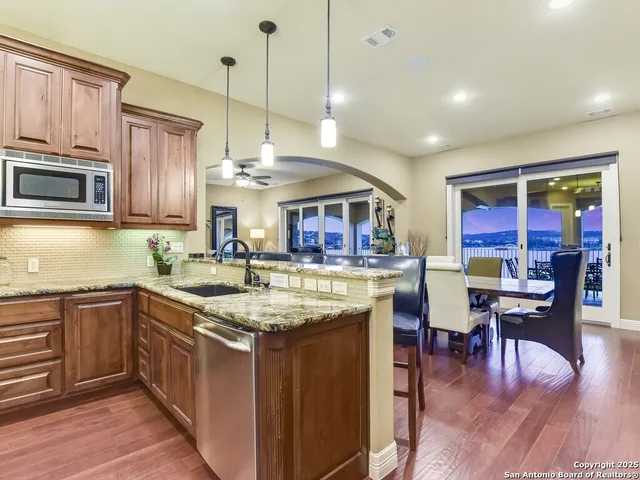 a kitchen with stainless steel appliances granite countertop a stove and cabinets