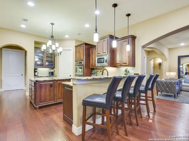 a kitchen with a dining table chairs refrigerator and cabinets