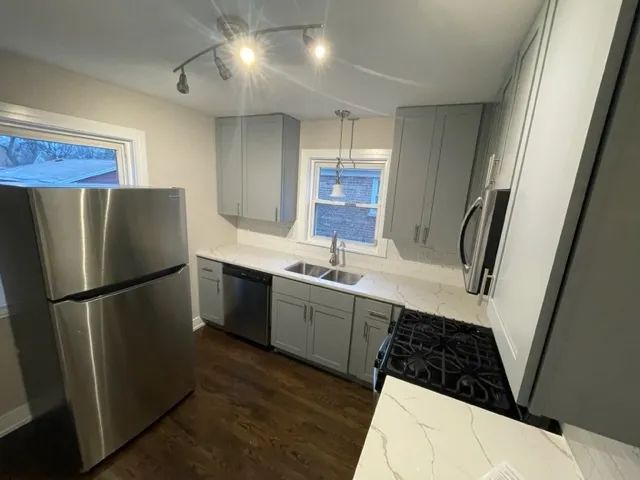a kitchen with a refrigerator sink and cabinets