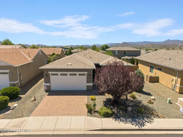 a front view of a house with a yard and a garden