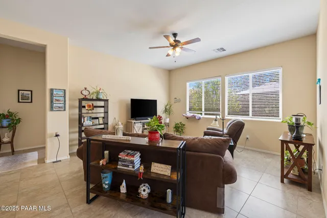 a living room with furniture kitchen view and a chandelier