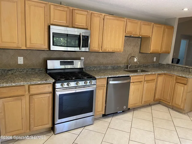 a kitchen with granite countertop a stove sink and cabinets