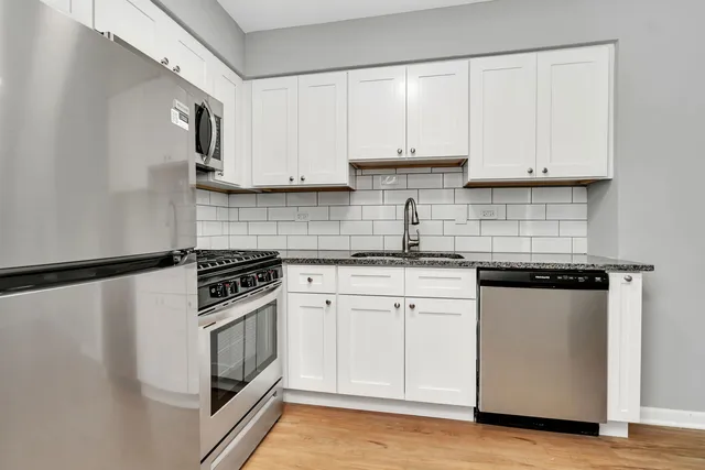 a kitchen with white cabinets and white appliances