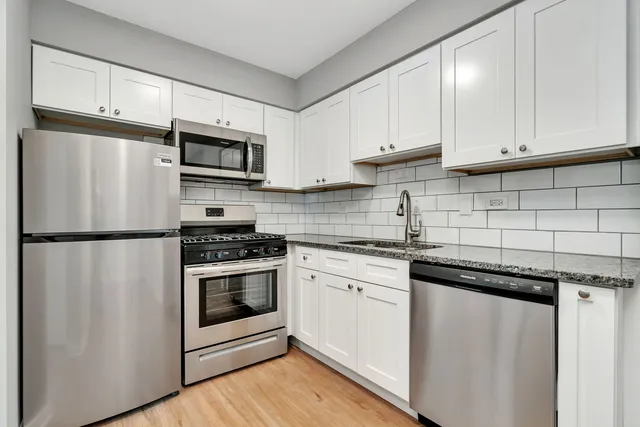 a kitchen with stainless steel appliances a refrigerator sink and cabinets