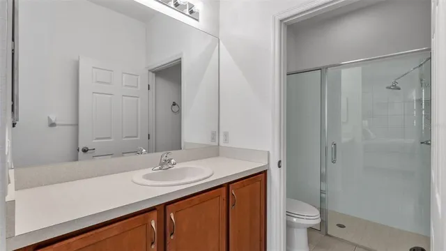a bathroom with a sink toilet a mirror and shower