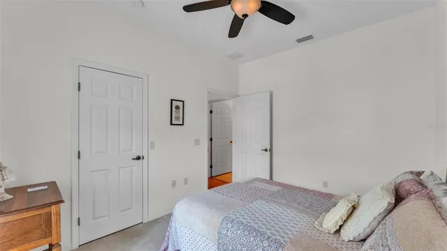 a bedroom with a bed and a ceiling fan