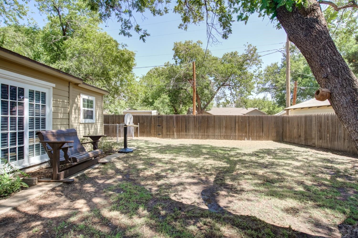 2714 29th Street Lubbock, TX 79410 - Photo 32 of 35 a backyard of a house with table and chairs and a large tree