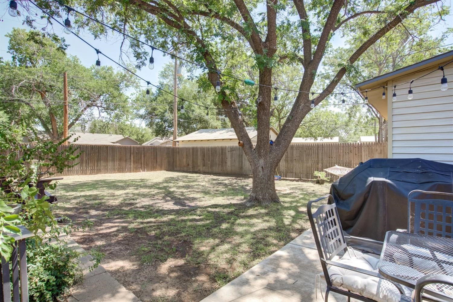2714 29th Street Lubbock, TX 79410 - Photo 33 of 35 a view of backyard with table and chairs and a large tree