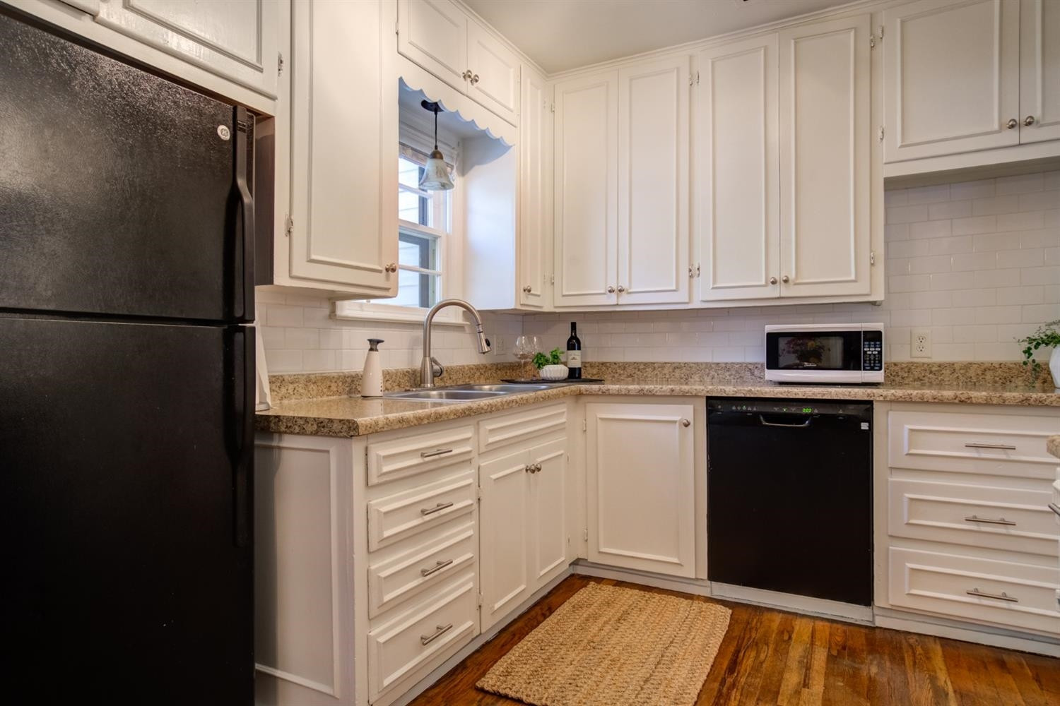 2714 29th Street Lubbock, TX 79410 - Photo 9 of 35 a kitchen with a refrigerator and white cabinets