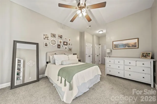 a bedroom with a bed a chandelier and a painting on the wall