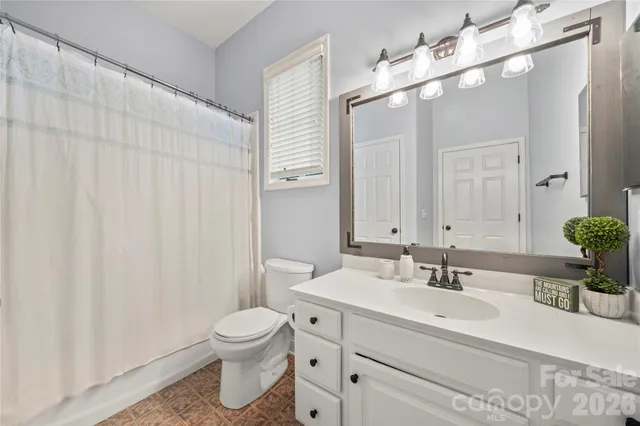 a bathroom with a toilet a sink and a mirror