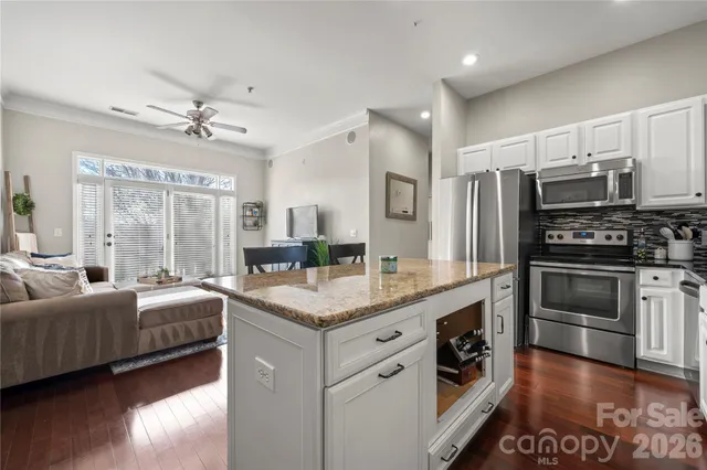 a kitchen with stainless steel appliances a sink cabinets and wooden floor