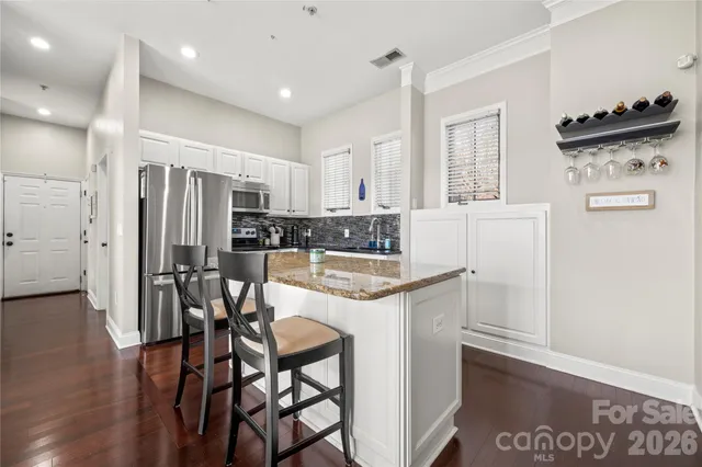 a kitchen with stainless steel appliances kitchen island granite countertop a refrigerator and a stove top oven