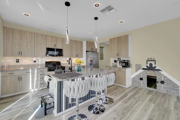 a kitchen with sink stove top oven and refrigerator