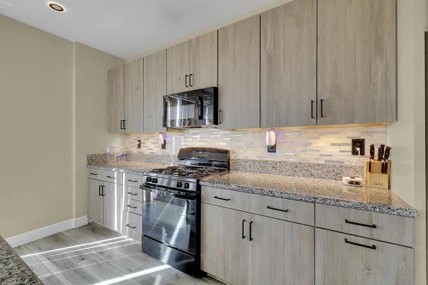 a kitchen with stainless steel appliances granite countertop a stove a sink dishwasher and a refrigerator with granite countertops