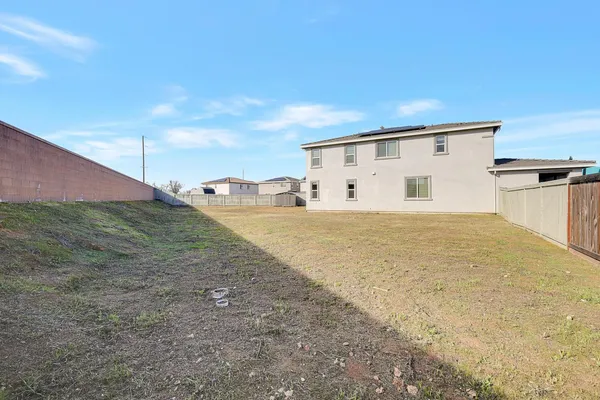 a view of a house with backyard and trees