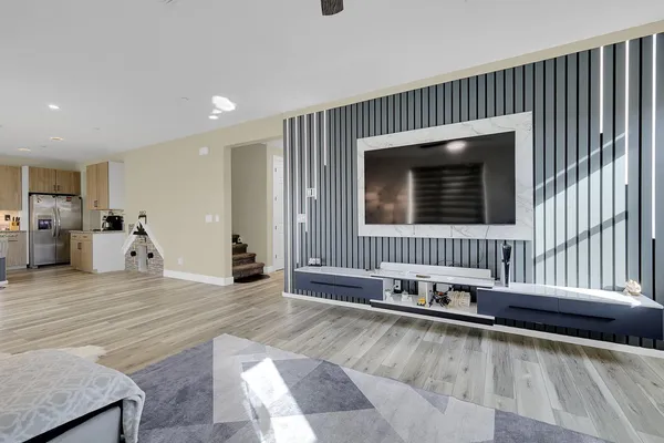 a living room with stainless steel appliances kitchen island granite countertop furniture and a wooden floor
