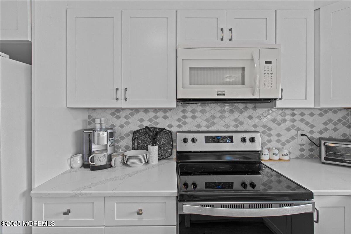 30 Dune Terrace Seaside Heights, NJ 08751 - Photo 12 of 42 a kitchen with white cabinets and appliances