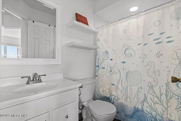 a bathroom with a sink a toilet and shower curtain