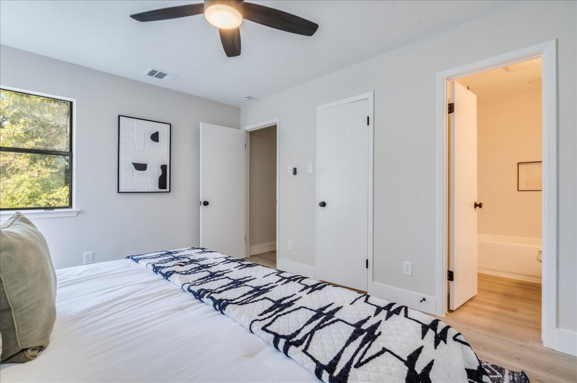 11301 Jollyville Road, Unit F2 Austin, TX 78759 - Photo 13 of 29 a bedroom with a bed and a chandelier