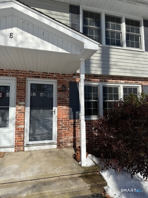 The front door facing the courtyard has a full glass newer storm door that lets in afternoon light as well as the triple windows to the right in the living room.