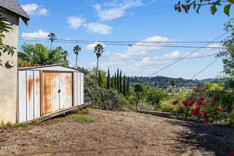a view of a house with brick walls and a tree